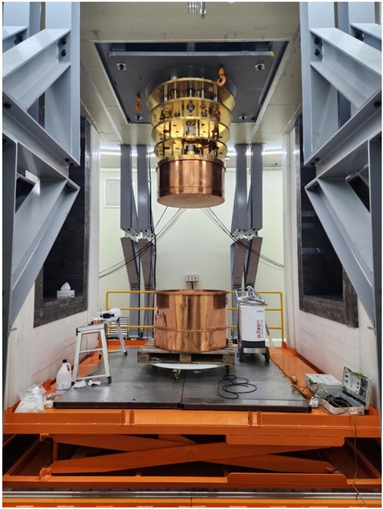 A massive copper cylindrical cryostat being installed by a large crane in the center of the laboratory. This facility will shield the detector from external radiation and maintain the ultra-low temperature for over 5 years to search for neutrinoless double beta decay of 100Mo.