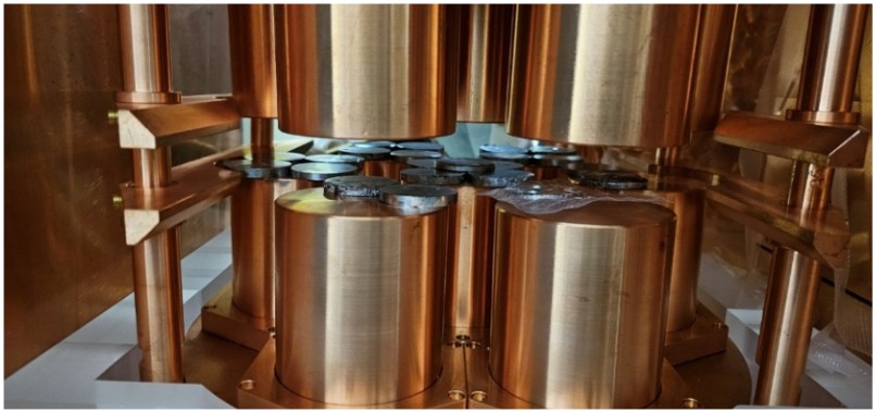A photograph of the experimental setup showing sample disks placed on top of the copper High-Purity Germanium (HPGe) detector cylinders.